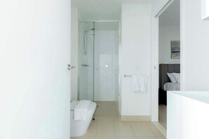 A modern bathroom with a glass shower enclosure, a toilet, and a sink area. - Executive 2BDR in Southbank w Parking. (Southbank)