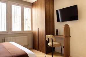 A bedroom with a bed, a wooden wardrobe, a desk with a chair, a television mounted on the wall, and a window. - Design Appartement a/c 2br/4p - Montmartre (Paris)