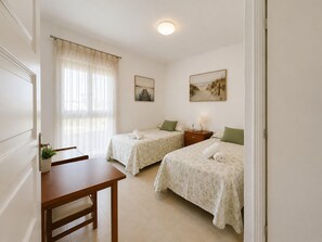 A bedroom with two beds, a desk, and a window with curtains. - Max Apartment With Communal Garden and Pool (Roquetas de Mar)