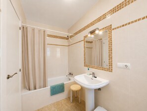 A bathroom with a bathtub, a sink, a mirror, and a towel rack. - Max Apartment With Communal Garden and Pool (Roquetas de Mar)