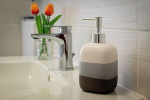 Ein Waschtisch mit modernem Wasserhahn und Seifenspender.