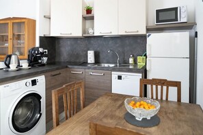 Eine kompakte Küche mit Waschmaschine, Mikrowelle und Geschirrspüler.