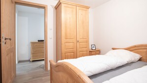 Ein Schlafzimmer mit einem hölzernen Bett, einem Schrank und einer Kommode – alles aus Holz.