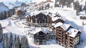 A ski resort with multiple multi-story buildings, ski slopes, and snow-covered trees. - Alps Flat With Heated Pool (Araches-la-Frasse)