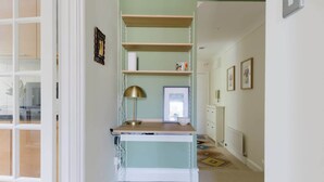 A room with a desk, shelves, a lamp, and a window. - Tasteful 2BDR Midcentury Modern Home (London)