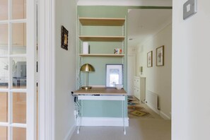 A room with a desk, shelves, a lamp, and a window. - Tasteful 2BDR Midcentury Modern Home (London)