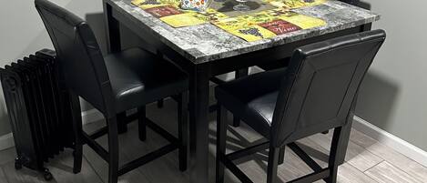 A dining table with a floral centerpiece, black chairs, and a patterned tablecloth.
