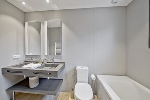 A modern bathroom with a double sink vanity, a toilet, and a bathtub. - Lecci Retreat Near Cala Rossa Beach (Lecci)