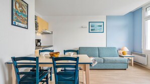 A modern kitchen with a dining table, chairs, and a sofa. - Premium 6-person Island Sanctuary (Île-aux-Moines)