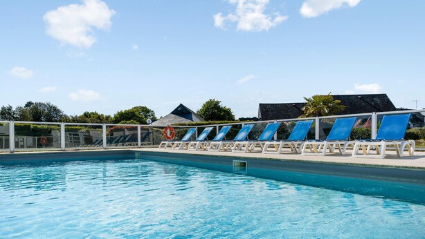A swimming pool with blue water, surrounded by white lounge chairs and a white fence. - Premium 6-person Island Sanctuary (Île-aux-Moines)