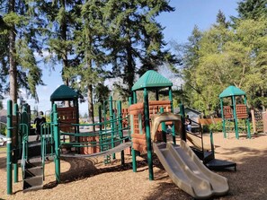 Ein Spielplatz mit Klettergerüsten, Rutschen und einem überdachten Spielbereich.