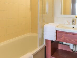 A bathroom with a bathtub, a sink, and a mirror. - Branville Duplex Apartment for 6 (Branville)