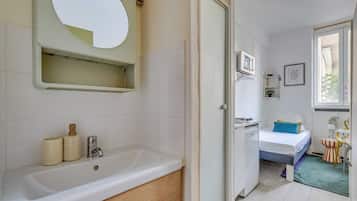 A bathroom with a bathtub, a mirror, and a toilet.
