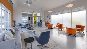 Ein modernes Interieur mit einer Couch, Sesseln, einem Couchtisch und einem Essbereich.