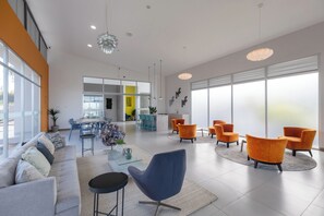 Ein modernes Interieur mit einer Couch, Sesseln, einem Couchtisch und einem Essbereich.