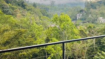 A lush green landscape with a view of a hill and a building in the distance.