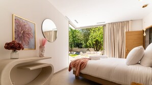 A modern bedroom with a bed, a vanity with a mirror, and a view of an outdoor area. - Villa Joy Pool Sauna River Escape (Murviel-les-Beziers)