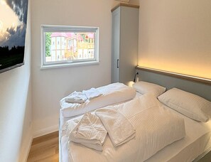 Une chambre à coucher avec un lit, une fenêtre et une table de chevet.