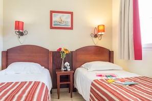 Une chambre dâhĂŽtel avec deux lits, une table de chevet, un vase avec des fleurs, une figurine de panda et un tableau encadrĂ© au mur.