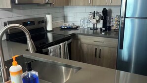 Een moderne keuken met roestvrijstalen apparatuur, een houten aanrecht en een inbouwspoelbak.
