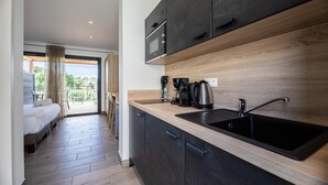 Una cocina moderna con un lavamanos negro, encimera de madera y armarios oscuros.