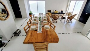 Un comedor con una mesa de madera preparada para seis personas, rodeada de sillas de madera.