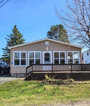 A single-story house with a front porch, a garage, and a number '20' sign.
