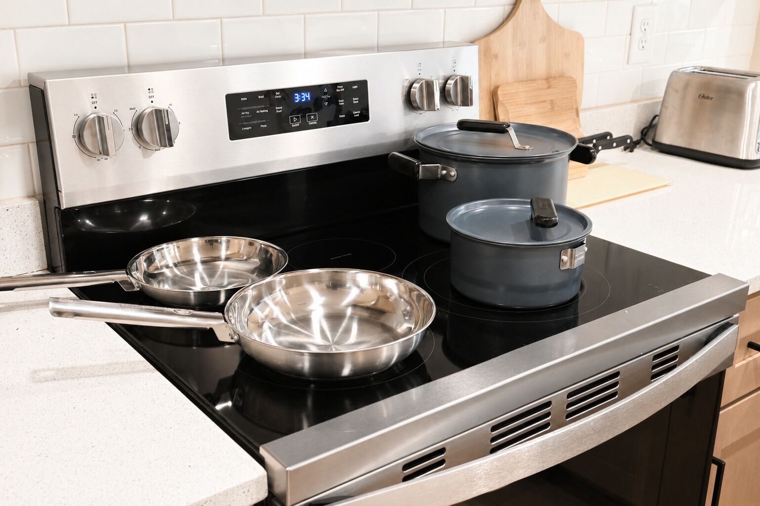 A kitchen with a stainless steel stove, two pots, and a toaster.