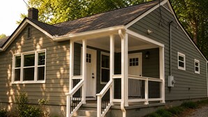 Une maison de plain-pied avec un porche à l’avant, une cheminée et un petit jardin devant.