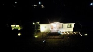 Ett hus med en veranda, en liten uteplats och ett garage som syns.