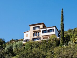 A two-story house with a stone facade, multiple windows, and a balcony. - La Torre CostaBravaSi - Pool, BBQ, sea views (Platja d'Aro)
