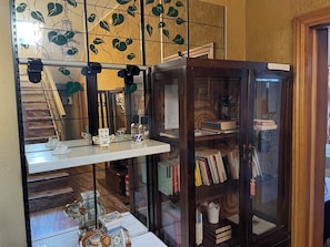 Ein Zimmer mit einer Holzhülle, einem kleinen Tisch mit Dekoration und einem Spiegel, der den Innenraum des Zimmers zeigt.