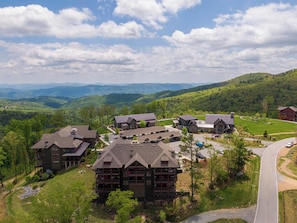 A lodge with multiple buildings, a parking area, and a view of surrounding mountains. - AEA - 198 Ramblestone NC (Banner Elk)