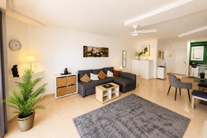 Ein modernes Wohnzimmer mit einer Couch, einem Couchtisch und einem großen Teppich.