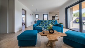 Ein modernes Wohnzimmer mit einer Couch, Hocker und einem Couchtisch.