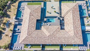 Ein Luftbild eines Resorts mit mehreren Swimmingpools, Liegebereichen und einem zentralen Innenhof.