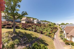 A residential area with houses, a pathway, and a tree. - Luxe Normandy Duplex for 8 With Pool (Houlgate)