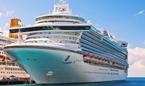 A large cruise ship with multiple decks, a prominent funnel, and a helipad.