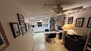 A narrow hallway with a dining area, kitchen, and a ceiling fan. - Quaint 2-bedroom house with AC in charming Karnack (Karnack)