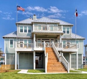 Ein zweigeschossiges Haus mit Balkon, Treppe und Garage.