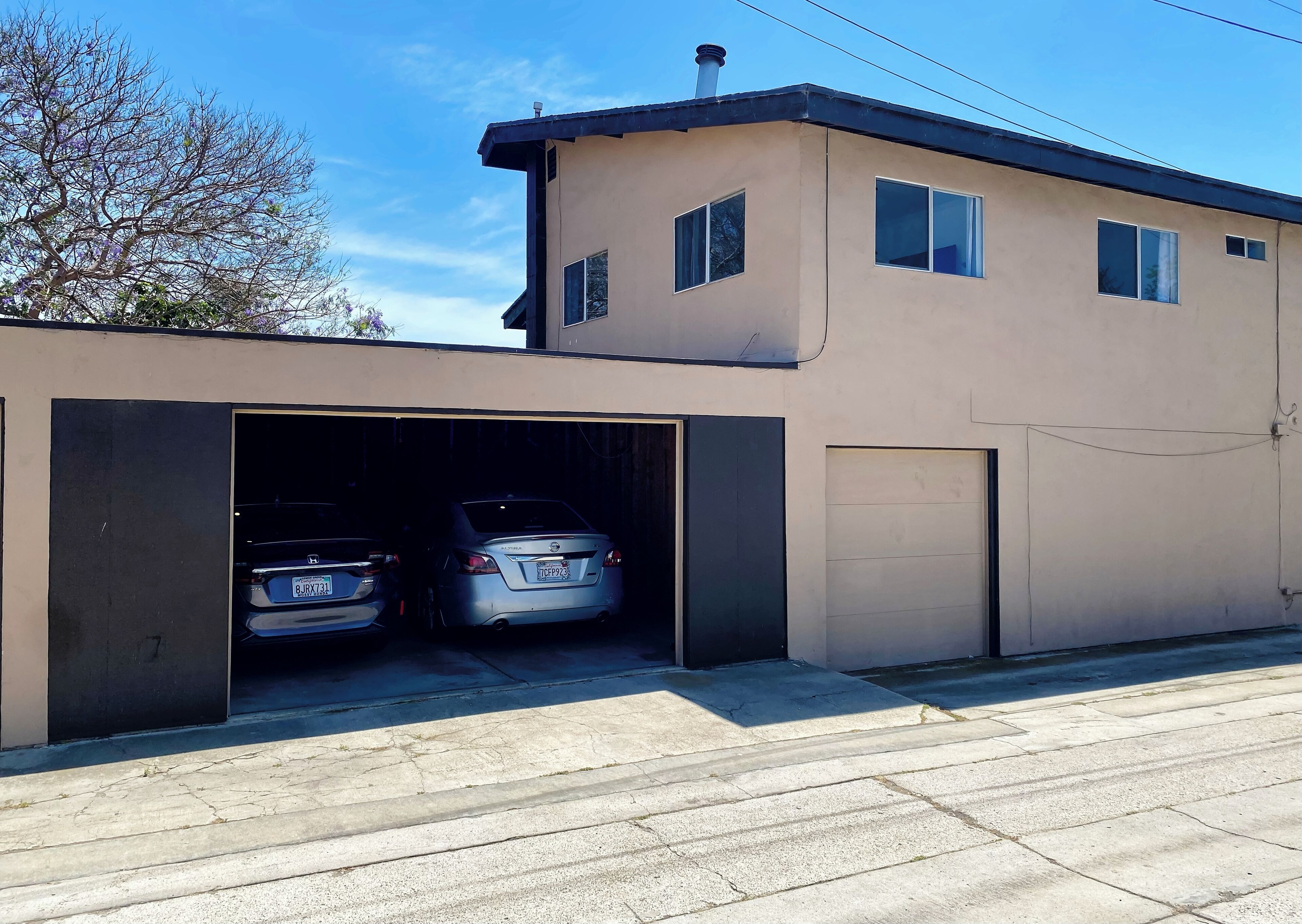 Un immeuble de deux étages avec un garage pouvant accueillir deux voitures.