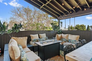 An outdoor patio with a fire feature, seating, and a pergola with string lights. - New 3 Blks Beach•Sleeps 12•Games/Movies•2 CarPrk! (San Diego)