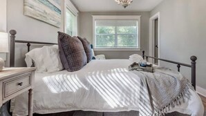 Une chambre à coucher avec un lit, une table de chevet et un lustre.