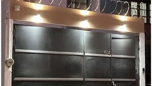 A large, dark-colored garage door with the number 614 on it, surrounded by a metal fence topped with barbed wire. - Serene 2-bedroom house with AC in Puerto Vallarta great location. (Puerto Vallarta)