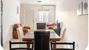 A dining area with a table, chairs, and a sofa. - Serene 2-bedroom house with AC in Puerto Vallarta great location. (Puerto Vallarta)