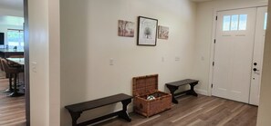 A hallway with a bench, a wicker basket, and two framed pictures on the wall. - Your retreat awaits! Plenty of space indoor and outdoor space. Pool, spa, OCT 26 (Fennville)
