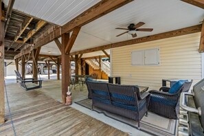 A covered outdoor seating area with wicker furniture and a ceiling fan. - Seas The Day, Waterpark, Close to Beach & Porch (Myrtle Beach)