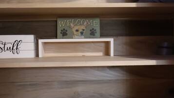 A wooden shelf with a 'Welcome' sign, a 'Stuff' sign, and a small framed picture.