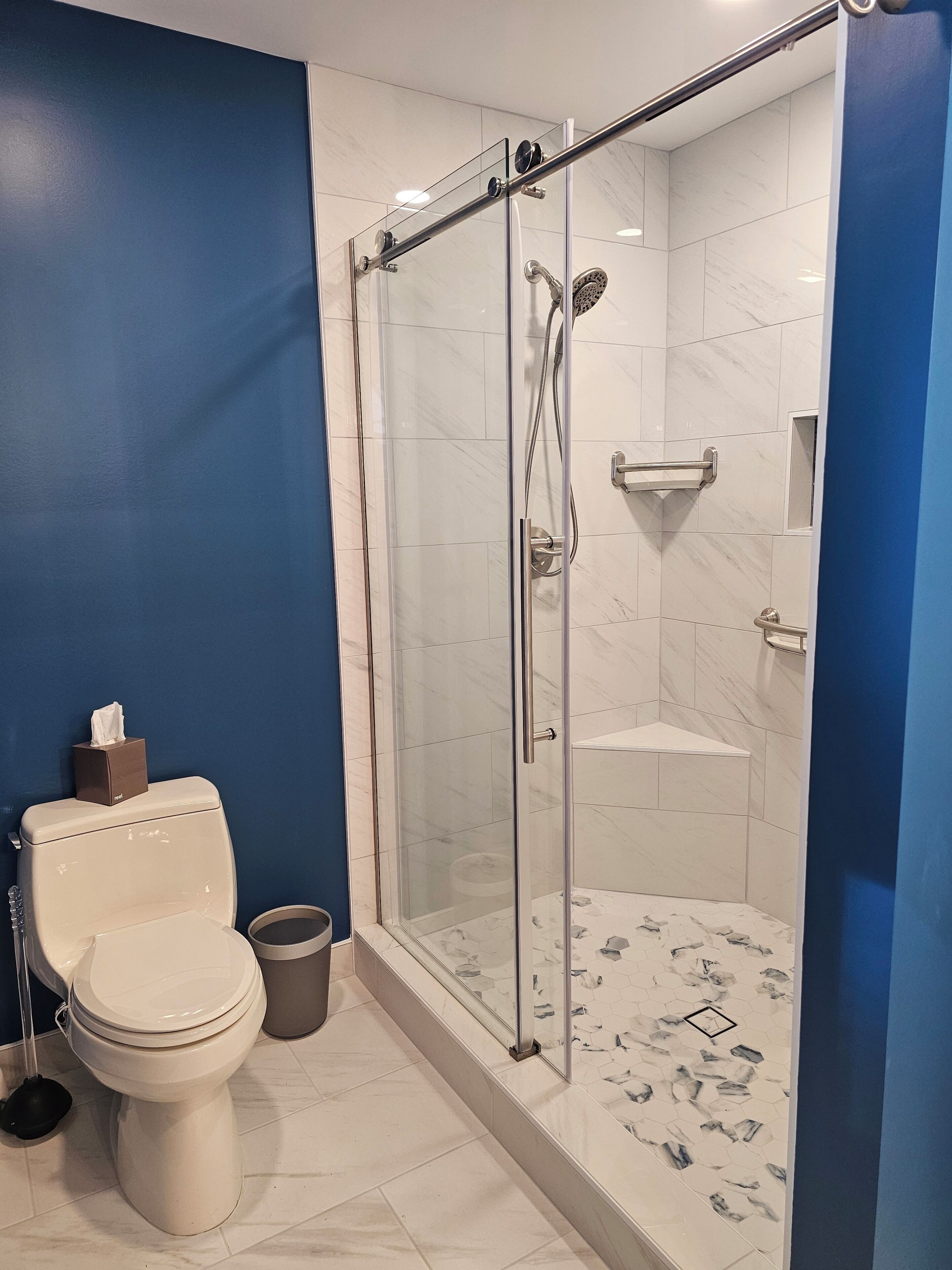A bathroom with a glass-enclosed shower, a toilet, and a bidet.