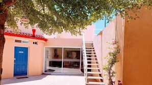 A narrow alleyway with a blue door, a glass door entrance, a staircase, and a potted plant. - Excellent independent room 11, centrally located, independent and autonomous (Hermosillo)